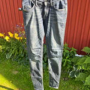 Low waist blå jeans från Tiger of Sweden  - Blå lågmidjade jeans från Tiger of Sweden. W 28 L 34. Smal passform. 