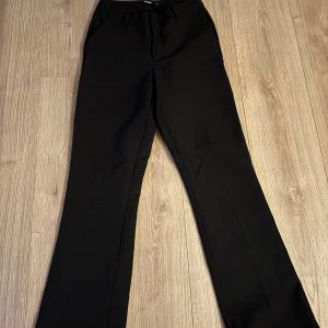 Svarta kostymbyxor från BikBok - Klassiska svarta kostymbyxor från BikBok i storlek 36. Byxorna är bootcut och mid waist! Säljer då de är för stora för mig. Har även ett par i storlek 34 om någon skulle vara intresserad!