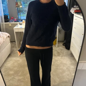 Mörkblå stickad tröja - Mysig mörkblå stickad tröja med rund hals och lång ärm. Tröjan har en enkel, klassisk design och är lite croppad i modellen🥰