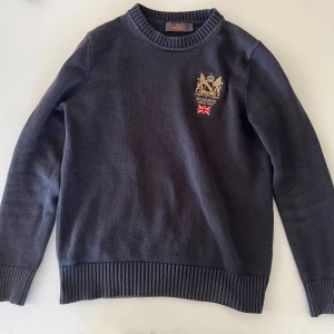 Mörkblå Morriströja - Mörkblå tröja med ett snyggt märke på vänstra bröstet. Har använts en del, men är fortfarande i bra skick. Är i storleken S!☀️