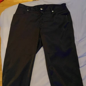 Svarta raka kostymbyxor - Snygga svarta kostymbyxor med klassisk rak passform. Byxorna har normal midja, diskreta fickor och stängs med knapp och dragkedja. Perfekta för en clean och stilren look. Materialet känns mjukt och följsamt.