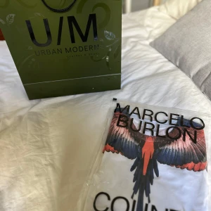 Marcelo Burlon vit t-shirt med fågeltryck - Snygg vit t-shirt från Marcelo Burlon med ikoniskt fågeltryck i blått, rött och svart över axlar och halsringning. Använd en gång!!! Köpt på Urban Modern på väla i Helsingborg, kvitto och orginalförpackning med påse medföljer. Ny pris 3100, strl S men passar M också. Pris är inte satt i sten.