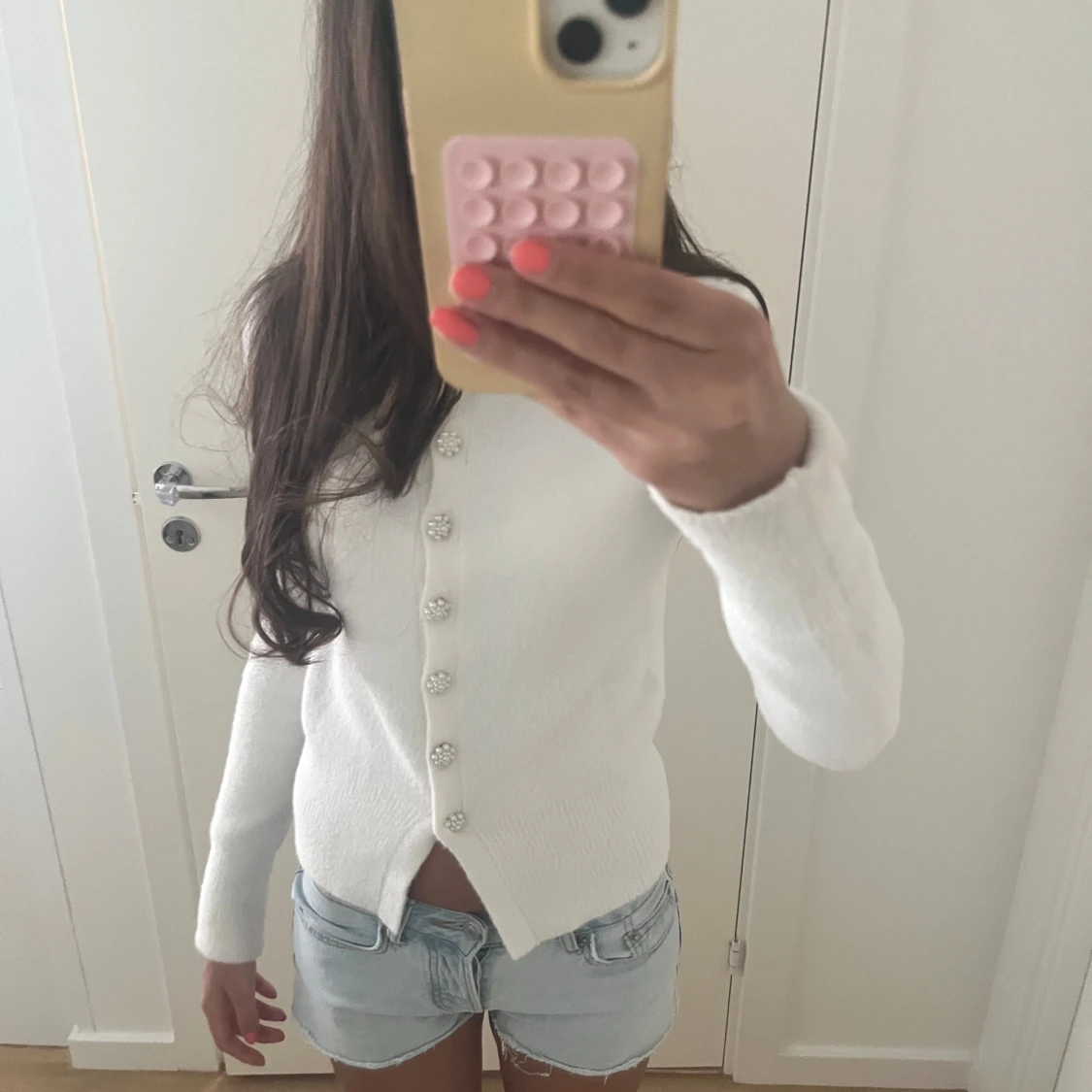 Vit kofta med pärlknappar