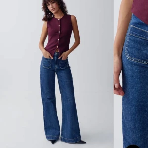 Blåa wide jeans med hög midja - Säljer ett par blåa jeans med hög midja och breda ben. Jeansen har stora, fyrkantiga fickor fram och bak, klassisk jeansknapp och synliga sömmar. Perfekta för dig som gillar en avslappnad och trendig look.