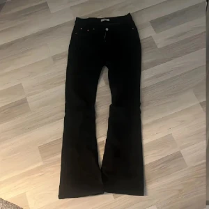Svarta bootcut byxor - Snygga svarta byxor med bootcut passform och klassisk femficksdesign. Byxorna har en något utsvängd benvidd och normal midja, perfekta till sneakers eller boots. Materialet känns mjukt och följsamt, vilket gör dem riktigt bekväma att bära.