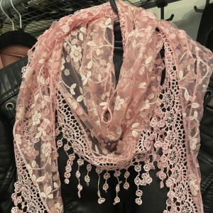 Rosa blommig spetsig scarf - Superfin ljusrosa halsduk / scarf / sjal i spets med broderade blommor och virkade detaljer. Halsduken har dekorativa hängande spetsbollar längs kanten och ett romantiskt blommönster som ger en söt och unik look. Perfekt accessoar för att lyfta din outfit.