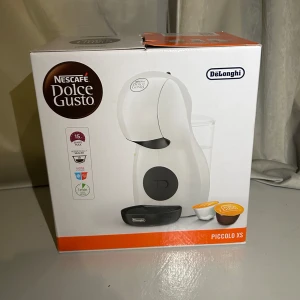 Kaffemaskin från Nescafé  - Säljer en oanvänd Nescafé Dolce Gusto Piccolo XS kaffekapsel maskin från DeLonghi. Aldrig använd och fortfarande i originalförpackning.  Den är: • Kompakt och stilren, tar inte alls mycket plats • Kan göra både varma och kalla drycker • Startklar på under 1 min • vit med svarta detaljer. Säljer den pga att jag köpt en annan 