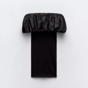 Svart offshoulder klänning Zara S - Supersnygg svart kortklänning från Zara med offshoulder och puffig volang upptill. Tight passform med tunna axelband och rak siluett. Perfekt för dig som vill sticka ut med en trendig och stilren look.