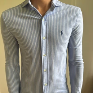 Blåvit randig skjorta från Ralph Lauren - Polo Ralph Lauren skjorta | Skick 10/10, nästan aldrig använda | Storlek XS, modellen på bilden är 182 cm och 70 kg och är lite för liten  | Nypris ca 2000 kr | Mitt pris 599 kr | Fraktar via postnord eller instabox🚚📦 Priset är inte hugget i sten och hör av dig vid minsta lilla fråga😊