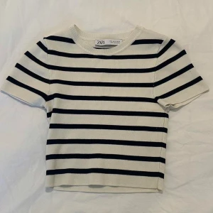 Randig topp från Zara i bomull - Superfin kortärmad topp från Zara med klassiska svarta och vita ränder. Modellen är croppad och har en rund halsringning. 