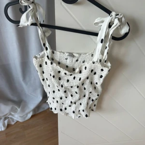 Prickig topp  - Ny prickig smockad topp. Endast testad. Går även att vika in banden och använda som tub topp, storlek S!