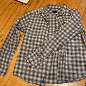 Rutig Peak Performance skjorta blå L - Tjena tjena! Jag Säljer en klassisk rutig skjorta från Peak Performance i blått och vitt. Skjortan har knappar framtill och bröstficka. Broderad logga på ärmen. Perfekt för dig som gillar en avslappnad men snygg stil.