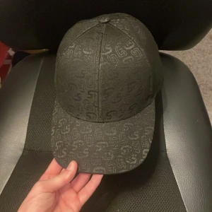 Svart keps från S. Luks med mönster - Svart keps från sixies perfekt för sommaren den ganska ny använt några gånger jätte fin keps