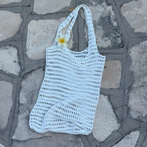 Virkad strand väska  - Virkad vit väska som är perfekt för stranden. Gjord i ett nätmönster och den rymmer väldigt mycket☀️