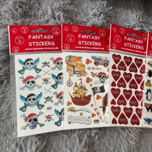 Fantasy Stickers - Färgglada klistermärken med pirater, fjärilar, insekter och hjärtan med 'Grattis'. Perfekt för att dekorera skolböcker, laptops eller presenter. Gör din vardag lite roligare och visa din personlighet med dessa coola stickers!