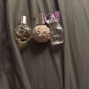 3 Ariana Grande miniparfymer - Säljer tre miniparfymer från Ariana Grande. En i kristallformad flaska med transparent glas, en i ljusrosa geometrisk flaska och en i lila transparent flaska med lila lock. Alla flaskor är i unik design och perfekta att ha med i väskan.Deras pris 500kr mitt pris 250kr