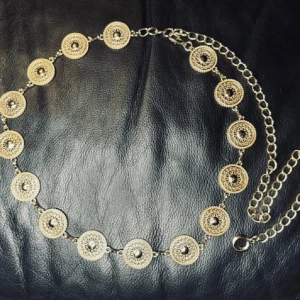 Nytt Gyllene Concho Belt Kedjebälte för Boho Western Festival Vintage Looks – Justerbart  -  Bohoinspirerat kedjebälte i guldig metall med dekorativa medaljonger. Ger en snygg vintagekänsla till både festival- och vardagslooken. Justerbar passform (ca 110 cm), medaljongerna är ca 3 cm breda. Helt nytt och oanvänt. Prutar ej, men erbjuder gärna rabatt vid köp av flera plagg. Passa på – jag rensar garderoben! 
