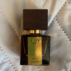 Rituals L'Essentiel Eau de Parfum 15ml - En lyxig parfym från Rituals, L'Essentiel Eau de Parfum i 15 ml flaska. Flaskan är mörkbrun och fyrkantig med en elegant guldfärgad etikett och detaljer samt en stor träliknande kork. Perfekt för dig som gillar stilrena och exklusiva dofter.