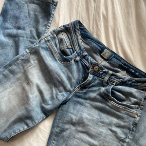 Ljusblå bootcut jeans från ltb - Säljer ett par ljusblå bootcut jeans från ltb, modell Molly. Jeansen har låg midja, klassiska fem fickor och snygga slitningar framtill och baktill. Perfekta för dig som gillar en avslappnad och trendig look.