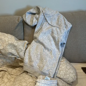 Ljusgrå mjukisbyxor med resår - Säljer ett par ljusgrå mjukisbyxor med tillhörande hoodie. Båda delarna är i storlek xs