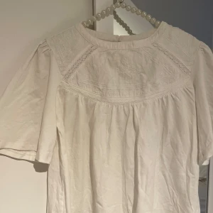 Vit blus - Supersöt vit blus med broderade detaljer. Superfin men lite liten och kommer inte till användning, därav säljer jag den. Det är barnstorlek 152, är som XS Använd fåtal gånger!