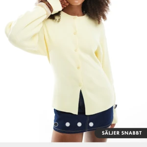 Butter yellow blus med knappar från Asos - Superfin ljusgul kofta med rund hals och raka, långa ärmar. Koftan har knäppning hela vägen framtill och är i ett mjukt, stickat material. Perfekt att slänga över en topp för en chill och fräsch look. Detta är storlek S. Nummer lapp finns kvar på grund av att jag aldrig hann returnera den. Jag älskade den, men vet inte vad jag ska bära den med. 