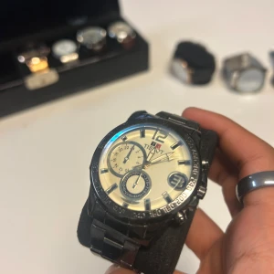 Tissot herrklocka i svart stål - Snygg Tissot herrklocka med svart länkarmband i stål och stor rund urtavla i silver. Klockan har flera små urtavlor, datumvisning och tydliga indexmarkeringar. Perfekt accessoar för dig som gillar stilrena detaljer och klassisk design. OBS batteriet funkar inte