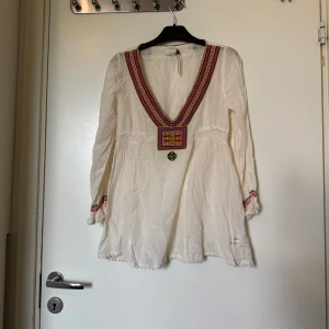 Odd molly topp  - Säljer en otroligt vacker längre creme färgad topp med fina broderade detaljer runt urringningen i rött, gult, vitt och svart. Från märket Odd Molly i storlek 0 som ungefär motsvarar en Storlek XS. Kanske kan vara rymlig i storlek. Mycket fint skick, jag hittar inga synlig anmärkningar eller defekter. 