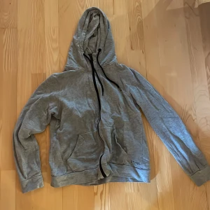 Zip-up hoodie - Säljer min brorsas grå zip hoodie med svart dragkedja eftersom han inte vill ha den längre. Storleken är M men passar även S