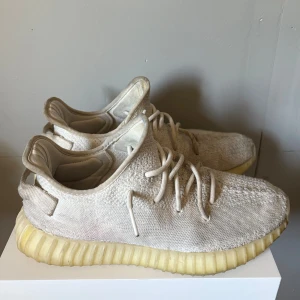 Adidas Yeezy Boost 350 Cream White - Säljer ett par Adidas Yeezy Boost 350 i färgen Cream White. Skorna har en stickad ovandel i beige/vit ton, klassisk ribbad sula i ljusgul och snörning framtill. Perfekta för dig som gillar streetwear och vill ha en clean look. Box och kvitto finns om ni har frågor bara skriva 