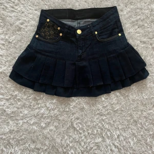 Mörkblå  jeanskjol - Lågmidjad jeanskjol omsydd från ett par jeans. Midjemått tvärsöver - ca 33  Längd - 31cm