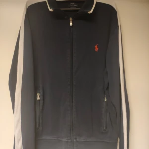 Blå zipup från Polo Ralph Lauren - Sälje denna zipupen från Ralph Lauren då den inte kommer till användning. Utmärkt skick utan defekter, priset är prutbart. Tveka inte på att ta kontakt för frågor och funderingar!