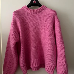 Rosa stickad tröja från Edikted - Chunky stickad tröja i en härlig rosa färg från Edikted. Oversized fit med breda ribbade muddar vid hals, ärmslut och nederkant. Perfekt för lager-på-lager och en mysig vibe. Långärmad och supermjuk känsla.