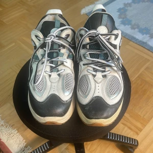 Eytys Jet Turbo Sneakers - Säljer ett par Jet Turbo sneakers från Eytys i svart, vitt och grönt. Skorna har en blandning av skinn och mesh, coola detaljer och tjock sula. Snygga kontraster med svarta och vita partier samt randiga snören. Perfekta för dig som gillar streetstyle.