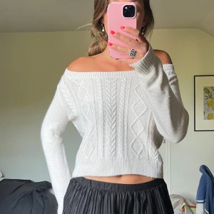 Vit offshoulder stickad tröja - Superfin vit stickad tröja med offshoulder-modell och snyggt flätmönster framtill. 