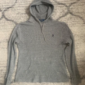 Ralph Lauren stikad hoodie  - Ralph Lauren stikad hoodie i grå färg som är köpt för 1999 och säljs för 399 och är i perfekt skick och om du har mer frågor eller vill ha mer bilder så skriv! 