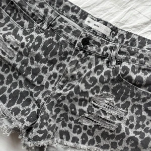 Grå leopardmönstrade jeansshorts från Zara - Säljer ett par grå jeansshorts från Zara med leopardmönster. Shortsen har slitna detaljer framtill, fransig nederkant och klassisk femficksmodell. I leoardmönster. Öppen för prisförslag. Skriv om ni har övriga frågor 💞