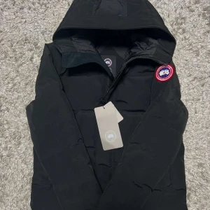 Canada goose macmillan - Väldigt skön jacka och varm är den 100%. Den har blivit använd igenom vintern och en del av våren. Den säljs så billigt med tanke på att det finns ett hål i vänstra armhålan, det syns inte om man inte kollar efter den. Det kan fortfarande sys vilket tanken är att den ska inom snar framtid