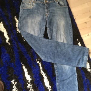 Blå jeans från Marc O'Polo - Säljer ett par klassiska blå jeans från Marc O'Polo med fem fickor och raka ben. Jeansen har en snygg tvätt och detaljer i kontrastsömmar. Perfekta för en avslappnad stil.