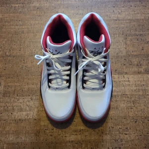 NIKE Flight Legacy Men's Sneakers Röd/Vit - Säljer ett par fräscha Nike Air sneakers i vitt med röda och svarta detaljer. Skorna har klassisk snörning, rund tå och en platt sula. Insidan är röd och ovandelen är i syntetmaterial. Perfekta för dig som gillar sportig stil.