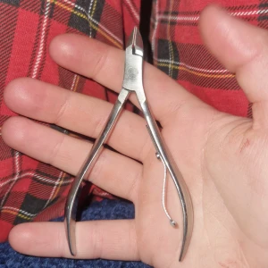 Nagelklippare i rostfritt stål - Nagelklippare i silverfärgat rostfritt stål med smal spets och ergonomiskt handtag. Perfekt för att klippa nagelband eller naglar med precision. Verktyget har en fjäder för smidig användning.