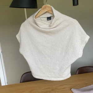 Beige stickad topp med lös polokrage från Gina Tricot - Säljer en beige stickad topp från Gina Tricot med lös polokrage. Modellen är ärmlös och har en avslappnad passform.💕💕