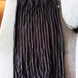 Svart ribbad långkjol stl M  - Säljer en svart långkjol med ribbad struktur och bred resår i midjan. Kjolen är enkel och stilren, perfekt att matcha med olika toppar. Materialet känns mjukt och följsamt.