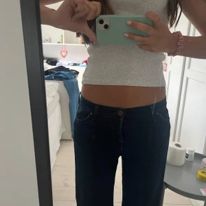 Ribbad grå croppad linnetopp - Säljer en ribbad grå croppad linnetopp med smala axelband. Toppen är figurnära och passar perfekt till jeans eller kjol. Enkel och stilren design som funkar till många olika outfits.