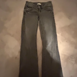 Grå jeansbyxor från Gina Tricot - Säljer ett par grå jeansbyxor från Gina Tricot med klassisk femficksdesign och dragkedja. Byxorna har raka ben och normal passform, perfekta för en avslappnad stil.