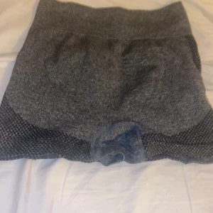 Grå tränings shorts  - Snygga grå shorts med ett diskret mönster och hög midja. Perfekta för träning eller en avslappnad dag. De har en tight passform som framhäver figuren.