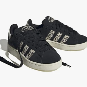 Adidas Campus sneakers med leopardmönster - Svarta Adidas Campus sneakers med de klassiska tre ränderna i vitt och leopardmönster på sidorna. Säljer pga att jag ska köpa nya skor. Dem är i bra skick men har gått upp underifrån lite, men vatten läker ej in i skon💞