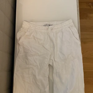 Vita linnebyxor med resår och snörning - Säljer ett par vita linnebyxor från lager157 med resår i midjan och snörning. Byxorna har sidfickor och en bakficka, perfekt för en avslappnad stil. Luftiga och sköna, passar bra till varmare dagar.