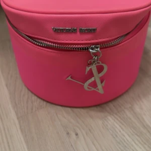 Rosa necessär från Victoria's Secret - Säljer en rund, knallrosa necessär från Victoria's Secret med silvrig dragkedja och logga framtill. Den säljs inte längre varken i Sverige eller i VS hemsidan, den producerades 2016 tror jag och är i otroligt bra skick!!! 💕💕💕