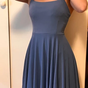 Blå klänning från BikBok - Säljer en blå klänning från BikBok med utställd kjol. Klänningen har en enkel, stilren design och är perfekt för varma dagar. Materialet känns mjukt och följsamt. 💙